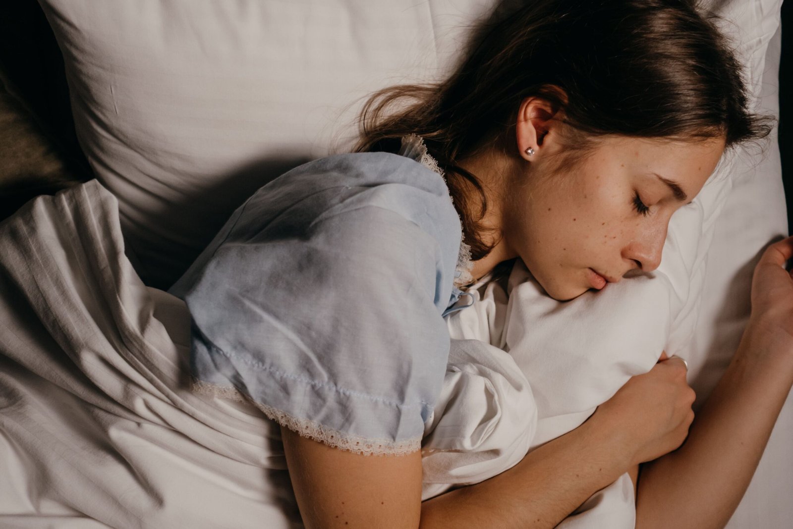 A person sleeping in a dimly lit bedroom